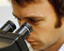 man looking through microscope